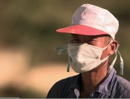 A_villager_from_Tae_Song_Dong_wears_a_mask_to_filter_out_dust_while_harvesting_rice_outside_of_the_village.jpg A_villager_from_Tae_Song_Dong_wears_a_mask_to_filter_out_dust_while_harvesting_rice_outside_of_the_village.jpg