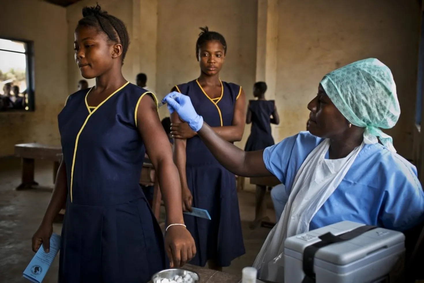 a nurse providing a vaccine to a young woman - uicc women and cancer