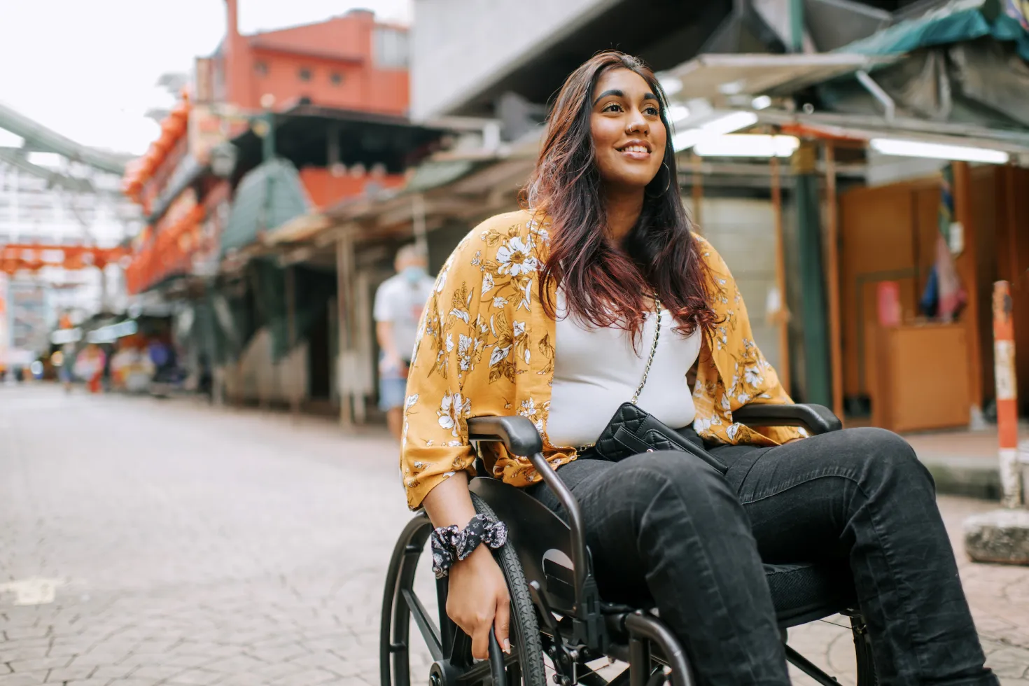 Young Asian Indian woman in a wheelchair in a city street