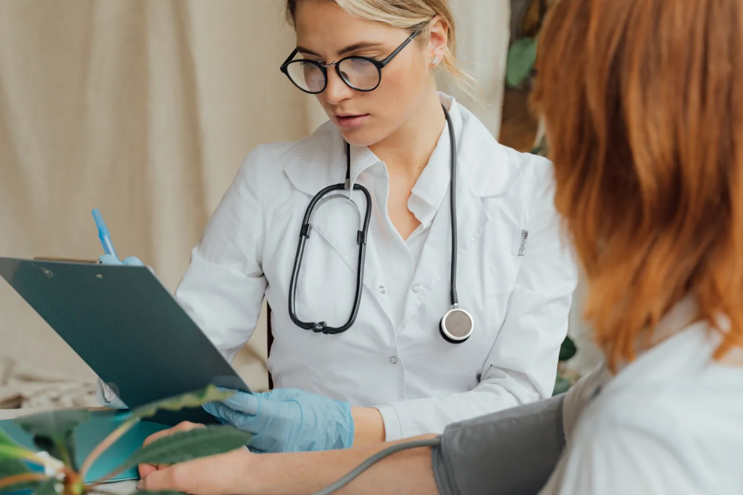 Woman having her blood pressure tested by a female doctor