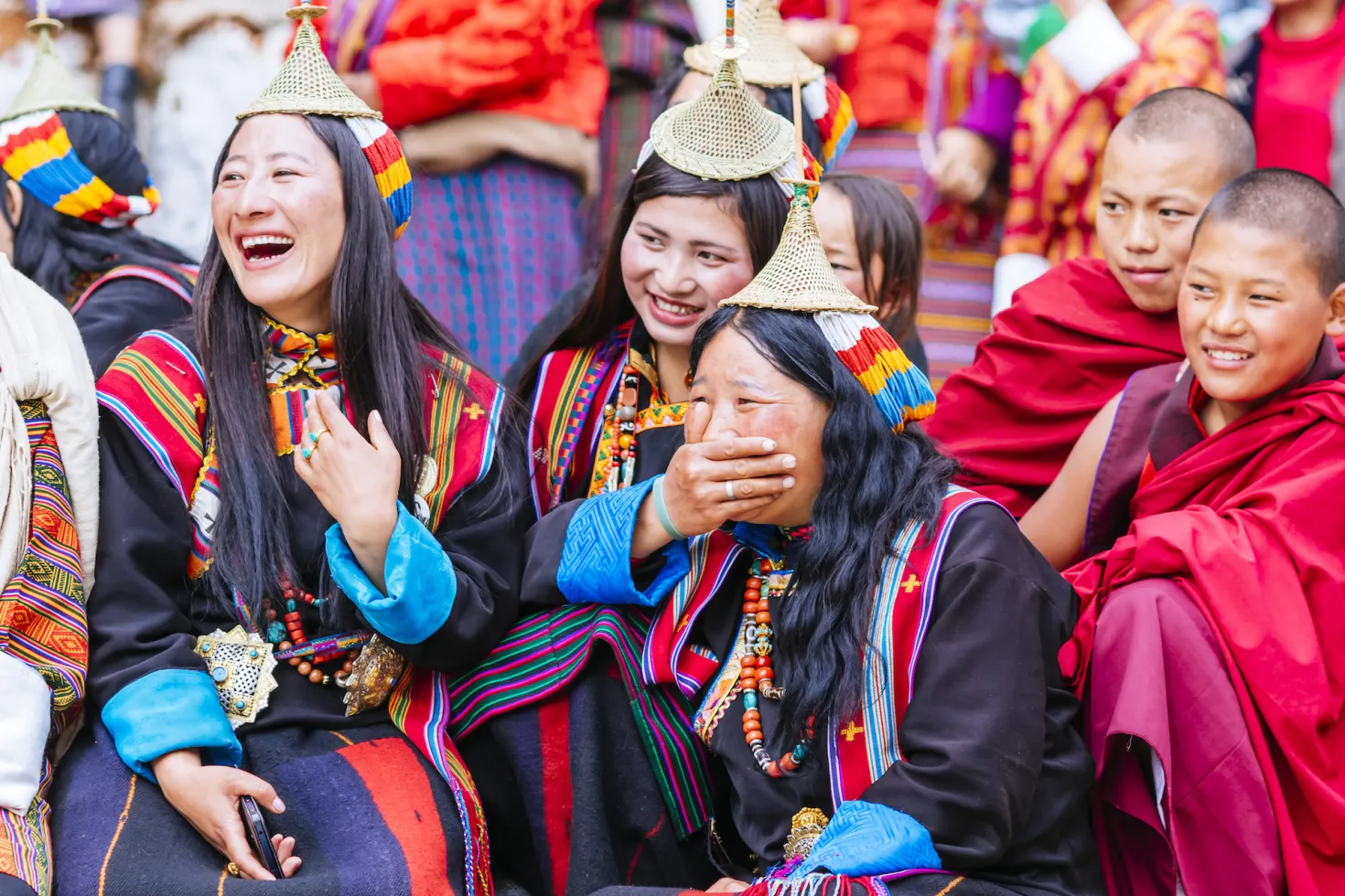 Group of women from Bhutan in traditional dress smiling and laughing