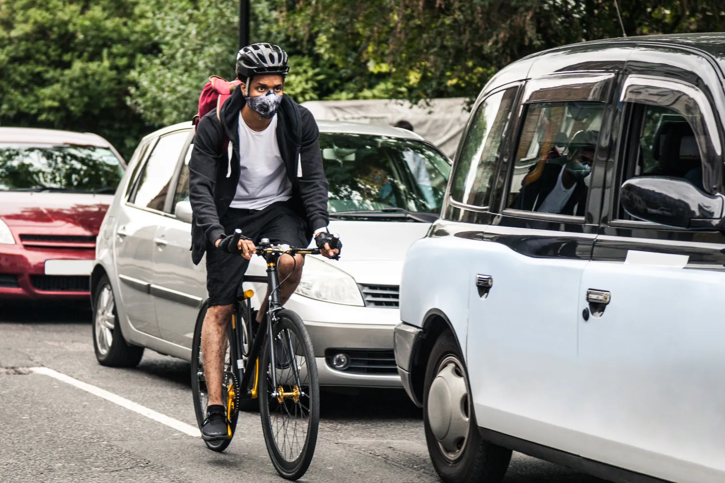 Cyclist wearing a pollution mask in central London as he commutes to work in the morning.