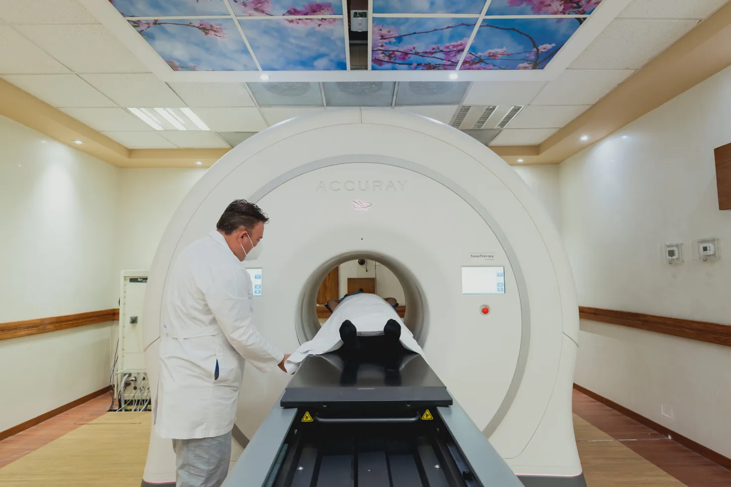 Cancer patient taking a magnetic resonance imaging (MRI) scan, with a health practitioner supervising