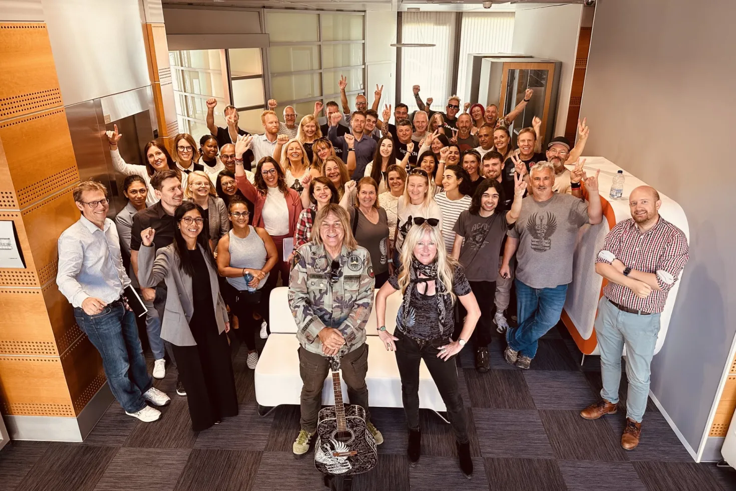 Mike Peters, front man for The Alarm, withi his wife Jules Peters at his side and surrounded by members of Love Hope Strength and UICC staff in the lobby of UICC offices in Geneva
