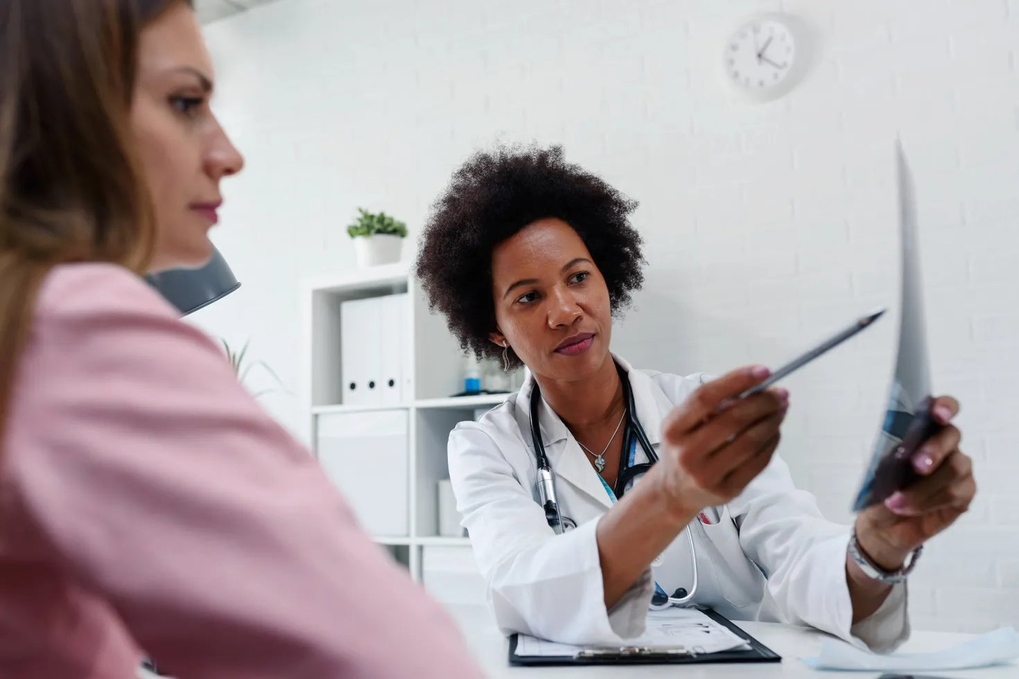 Black female doctor looking at test results of her patient