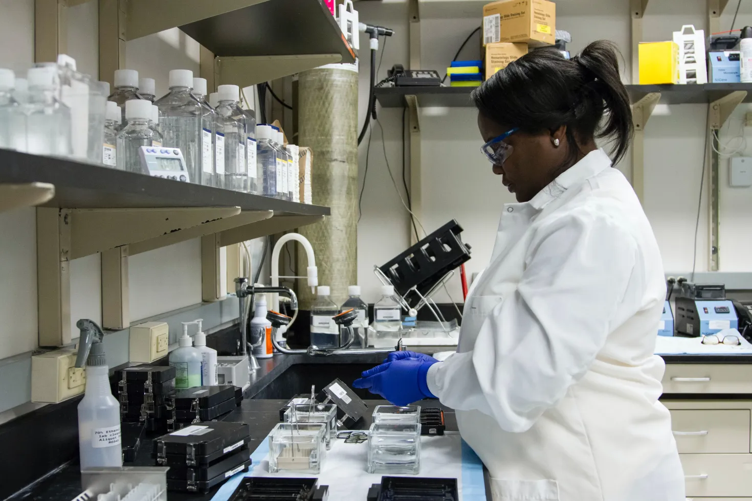 Black woman in lab coat running analyses