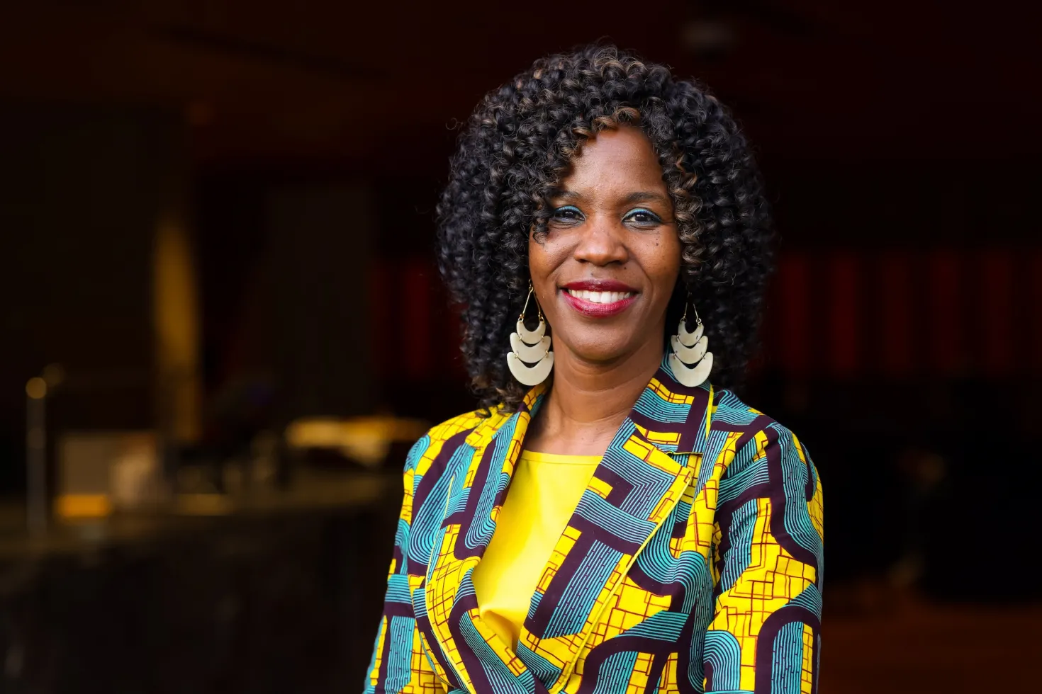 Dr Miriam Mutebi, UICC Board Member, an African woman in green and yellow clothing