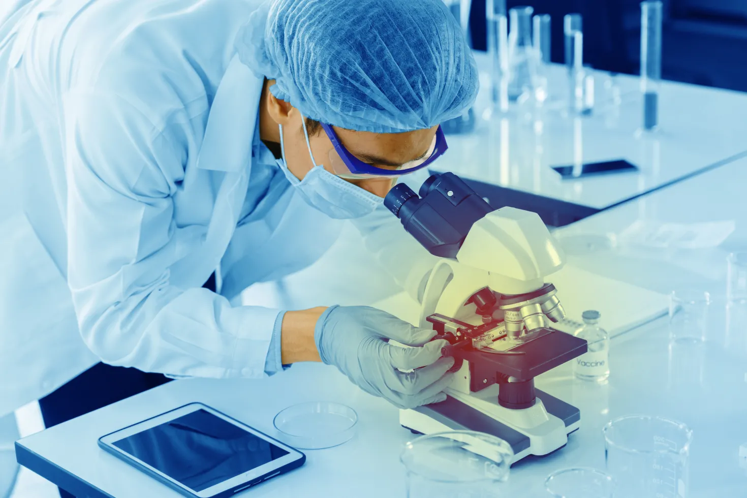 Lab technician looking at samples in a microscope