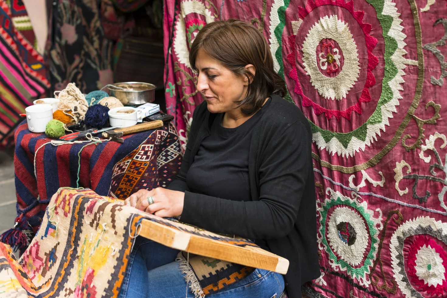 Eastern European woman weaving a carpet
