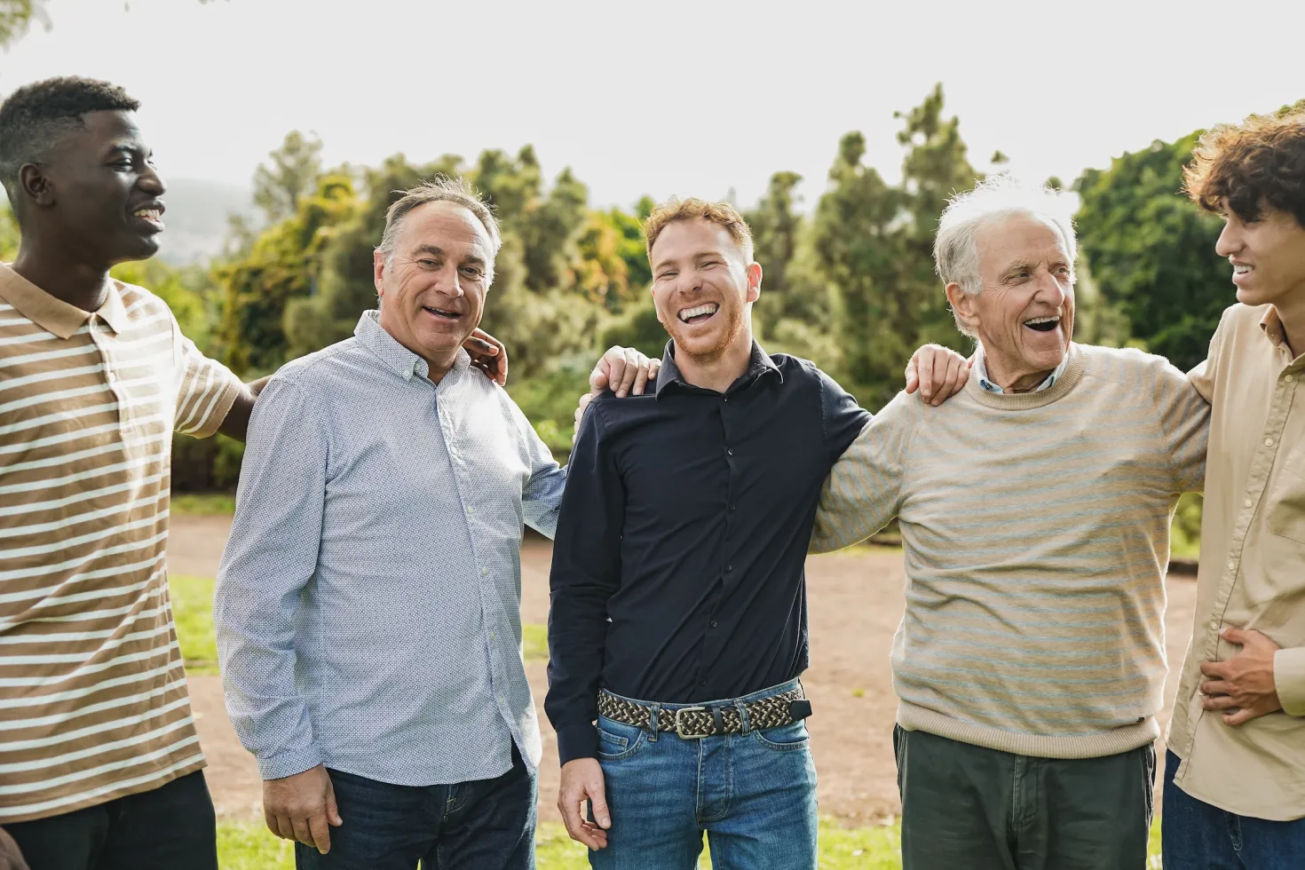 Multi generational men having fun together at city park - Multiracial male friends enjoy day outdoor