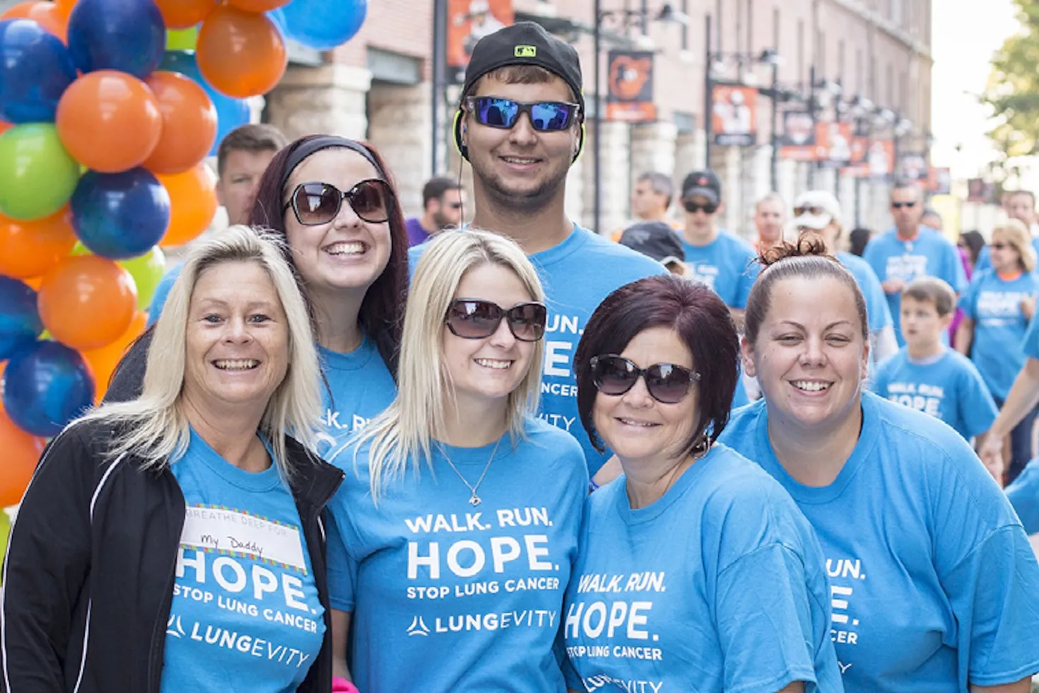 Diverse group of men and women in a branded blue LUNGevity shirts before a 5k walk event