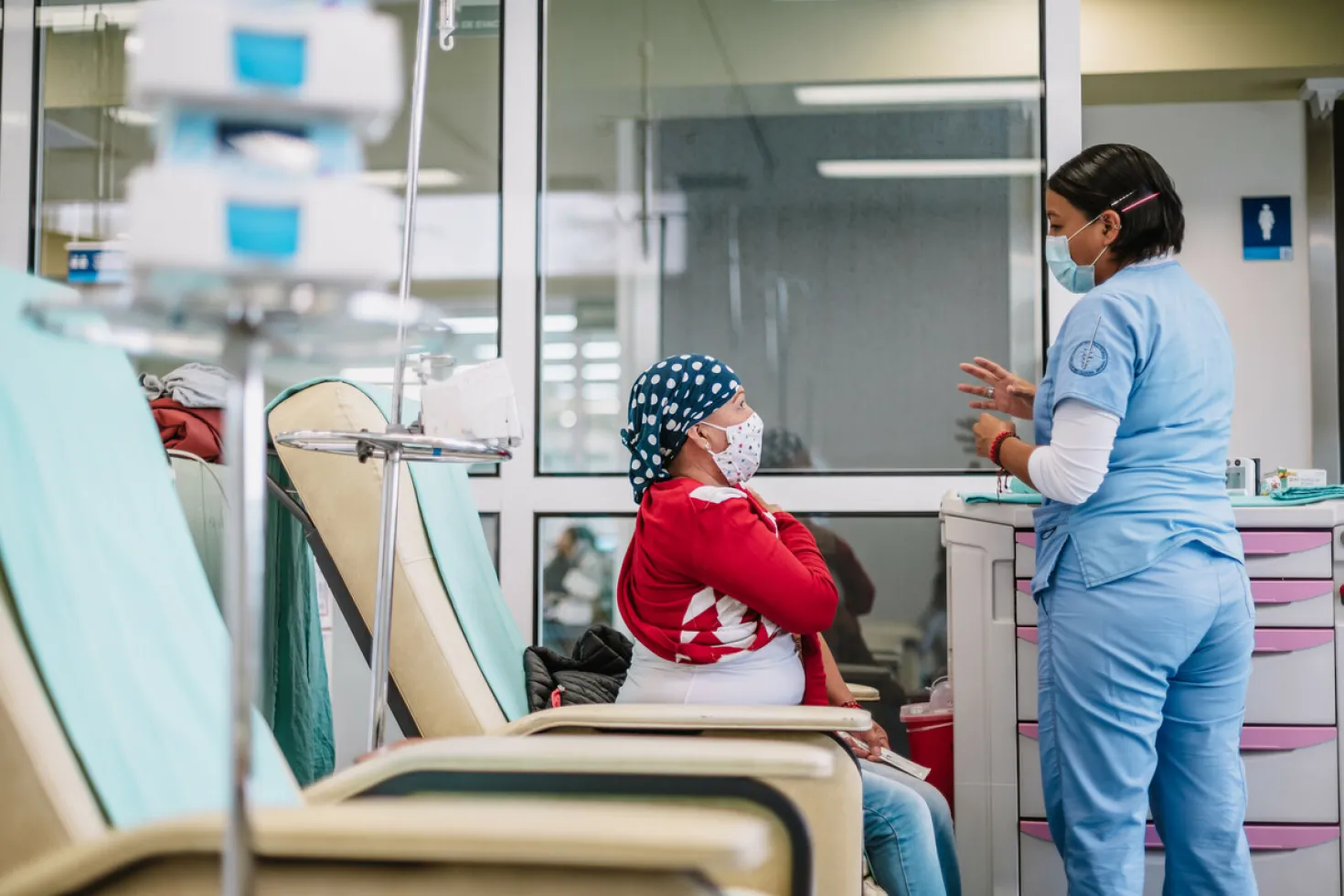 Caregiver talking to a woman who has just received cancer treatment