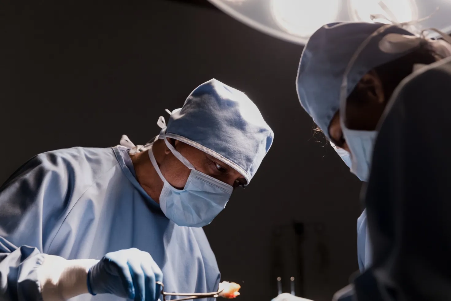 Image shows surgeon at work, emphasising the importance of comprehensive healthcare on in cancer control