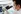 Asian man wearing a mask looking into a lab microscope