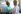 African nurse seen from behind taking the blood pressure of a young African girl wearing a turquoise shirt, smiling