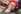 Black woman with red headscarf and wearing headphones smiles to the camera
