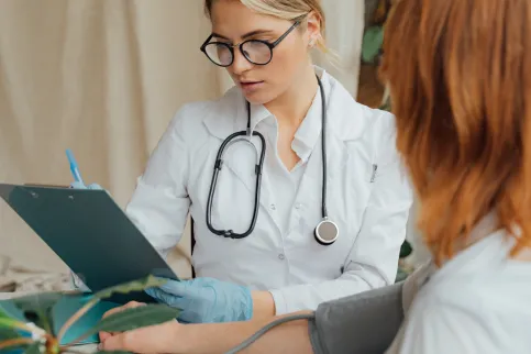 Woman having her blood pressure tested by a female doctor
