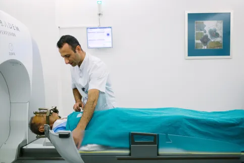 Male patient being placed by male caregiver on a scanning bed at Acibadem Kozyatağı Hospital, Turkey