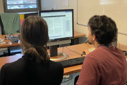 UICC Technical Fellow Javier David Benítez Fuentes with a woman colleague at IARC reading a report on a computer screen during his Fellowship at IARC