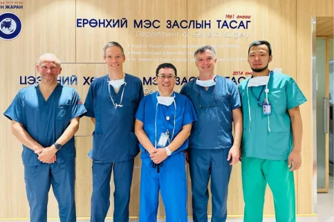 Five male doctors smiling to the camera