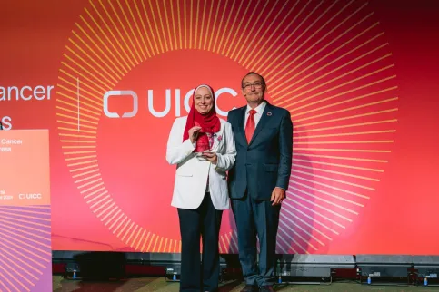 A photo of Hanaa Serry holding the World Cancer Day Award standing next to Jeff Dunn, UICC President at the World Cancer Congress 2024