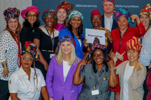 Diverse group of about 15 women wearing traditional hats