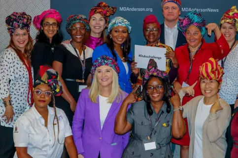 Diverse group of about 15 women wearing traditional hats