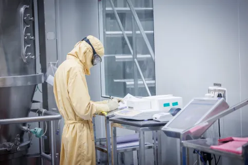 Man in yellow hazmat suit in a lab