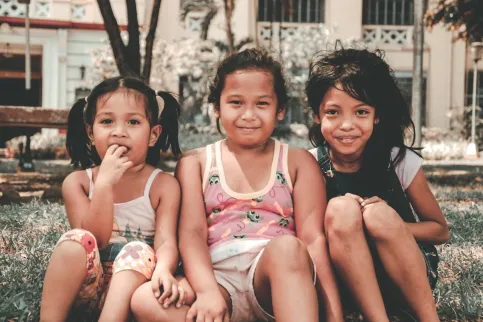 Three girls of different ethnicities smiling into the camera