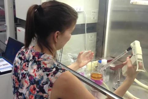 Woman in sleeveless flower dress checking lab equipment