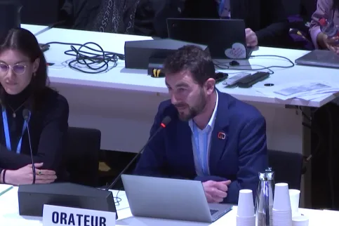 A Caucasian man giving a presentation at the World Health Organization