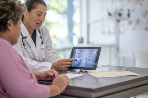 Female Hispanic doctor at an appointment with an older Hispanic woman.
