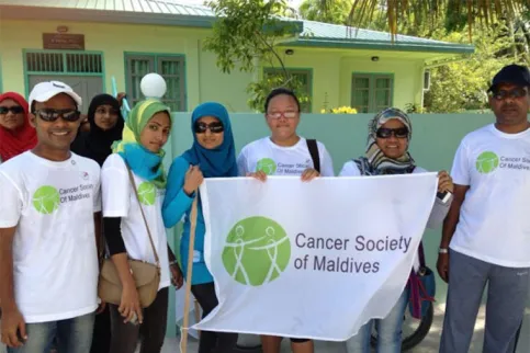 Volunteers of the Cancer Society of Maldives holdling up the organisation's banner