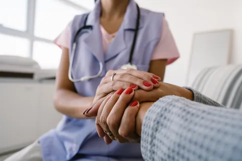 Nurse assisting a patient, close up of holding hands