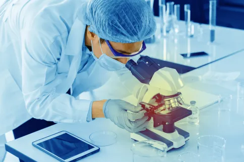 Lab technician looking at samples in a microscope