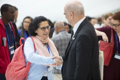 Women shaking hands with older man