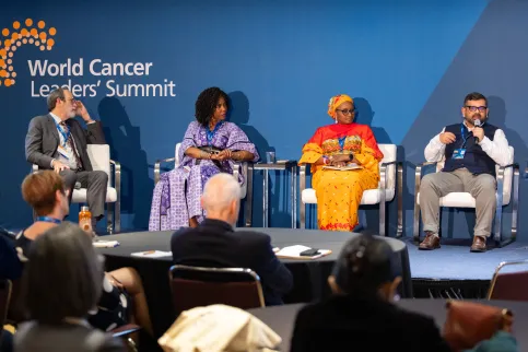Diverse panel at World Cancer Leaders' Summit branded in background