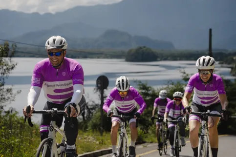 Cyclist uphill with lake and mountains in the background
