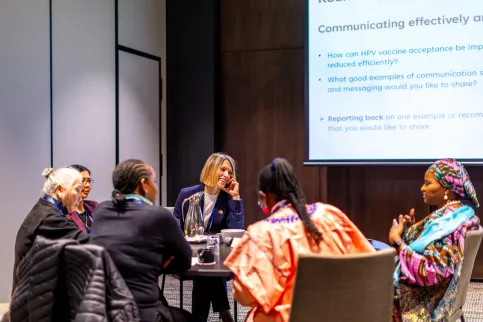 Six women of diverse ethnic and racial origins sitting around a roundtable in business setting