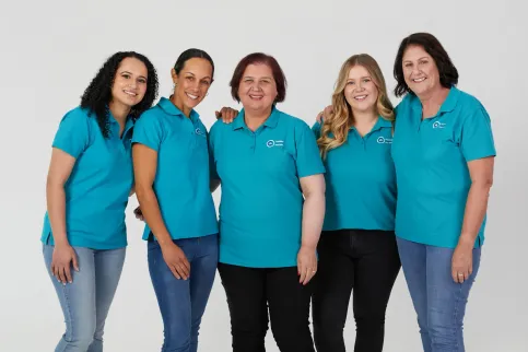 Diverse group of five women wearing turquoise branded shirts for Ovarian Cancer Australia