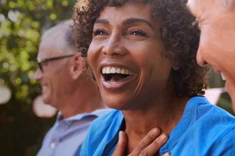 Black woman smiling and text overwrite "Early Detection = Better Outcomes"
