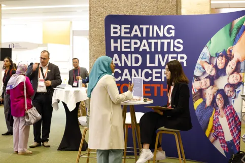 People at a conference, in front of a backdrop "Beating hepatitis and liver cancer"