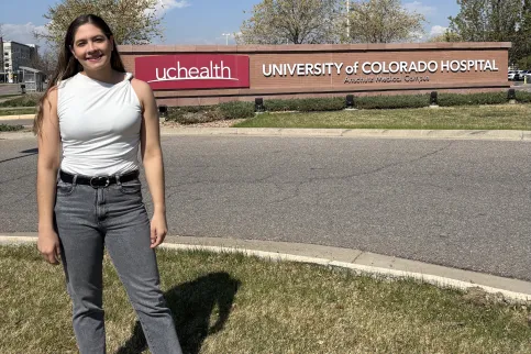 Young Latin American woman standing in front of the University of Colorado