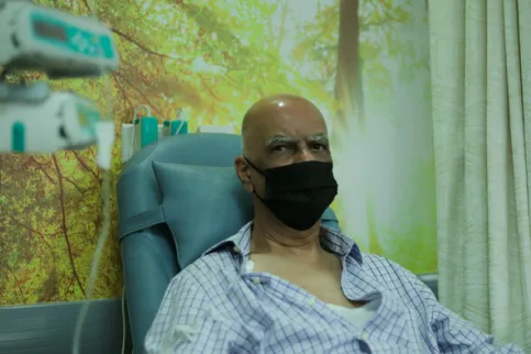 Man wearing a mask undergoing cancer treatment