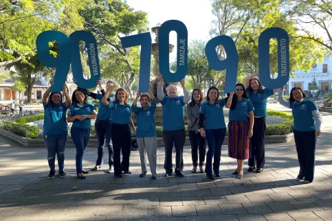 Staff of the Liga Nacional Contra el Cáncer Guatemala holding up number signs to spell out WHO's 2030 targets for cervical cancer elimination: 90, 70, 90
