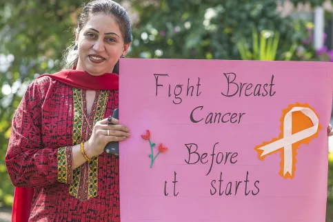 Woman at a breast cancer awareness campaign in Pakistan holding up a signpost that says: "Fight breast cancer before it starts". Photo by UICC is offering grants to members for projects aimed at improving access to early detection. Photo by Salman Asif/UN Women Asia and the Pacific,  breast cancer awareness campaign in Pakistan in 2013.