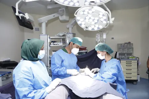 Three doctors at the Shaukat Khanum Memorial Cancer Hospital and Research Centre operating on a patient