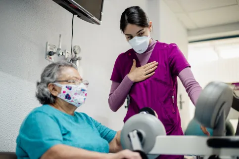 Older adult with cancer exercising on a stationary bike guided by a health worker at INCan, Mexico. Photo by Adán Jardón, (c) UICC.
