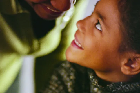 Close up of a woman looking down at her smiling daughter