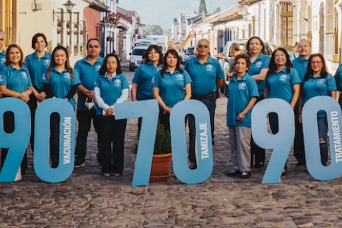 Women holding up large numbers 90, 70, 90